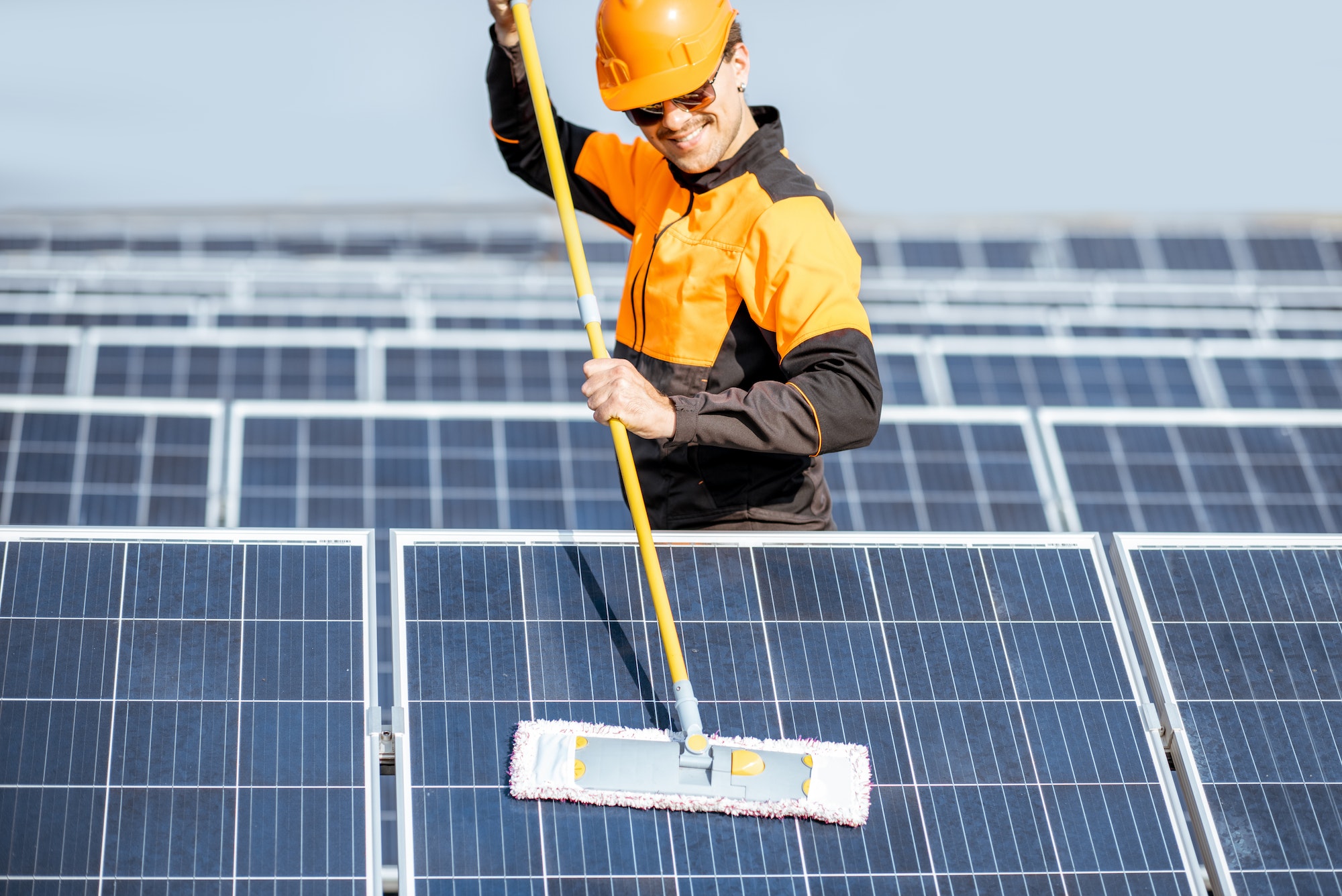 Workman cleaning solar panels