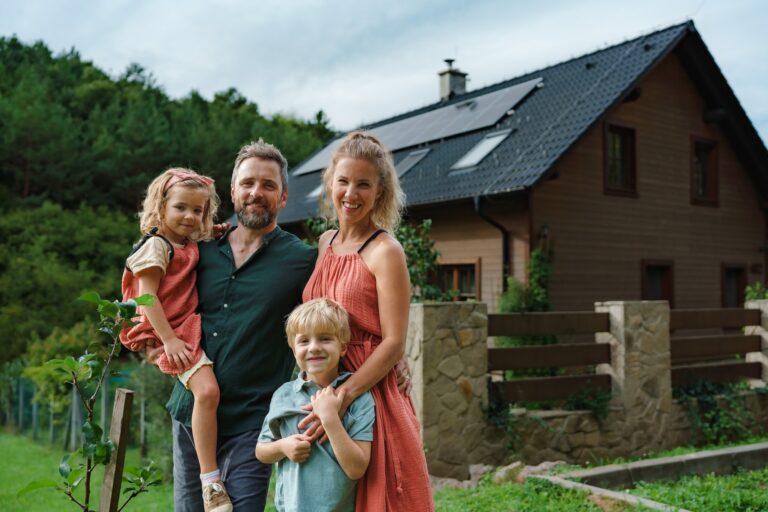 Happy family near their house with solar panels. Alternative energy, saving resources and